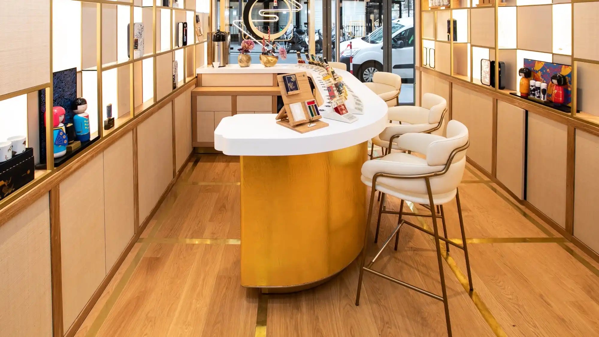 Curved golden counter with white top and beige bar stools.