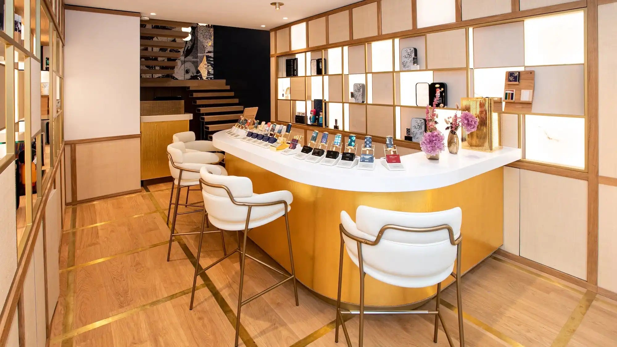 Curved yellow bar counter with white top and modern white bar stools.